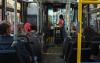 A young woman pays her fare as she boards a bus